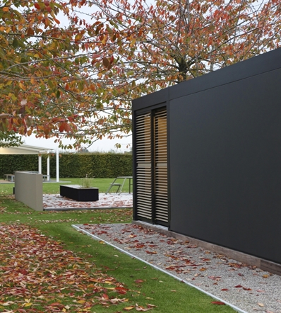 Linarte aluminum cladding wall incorporated as side enclosure of an aluminum pergola on patio