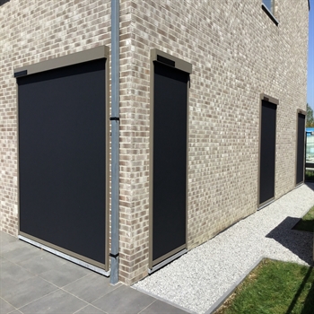 solar powered motorized screen with black fabric installed on a brown and grey home