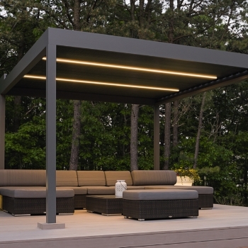 Lineo lighting integrated into the louvers of an outdoor aluminum retractable pergola shown at night