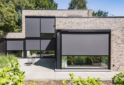 solar powered exernal window screen in black installed on brick style home