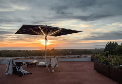 A center pole umbrella with built in LED lighting strips on a patio