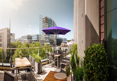 A single medium sized purple umbrella on an elevated restaurant patio 