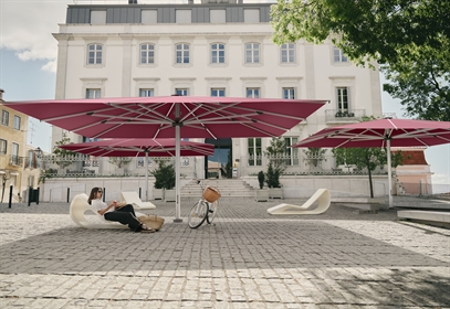 3 giant pink umbrellas in a public courtyard space