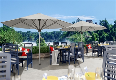 2 large white center pole umbrellas on a commercial patio overlooking trees