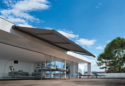 A dark coloured awning wall mounted to the edge of a home 